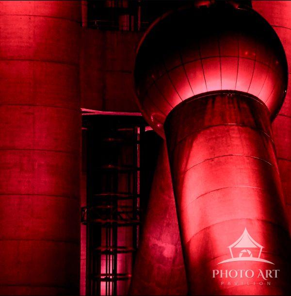 Bathed in an intense red glow, the structure rises with a commanding, almost otherworldly presence.