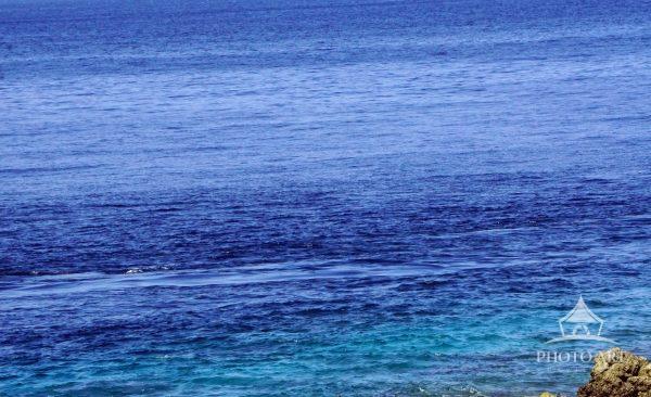 Layers of blue stretch into the horizon, where gentle currents shift between deep and turquoise