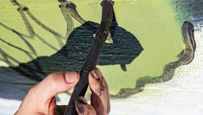 The shadow cast by the muralist's hand and brush becomes a moving part of the painting - an