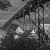 A striking black-and-white view of the New River Gorge Bridge showcases the massive steel arch