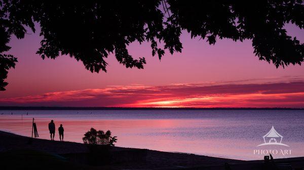 A couple while taking an early morning walk along the beach the most beautiful sunrise was showing