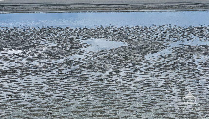 Receding tide leaving behind ripples in the sand