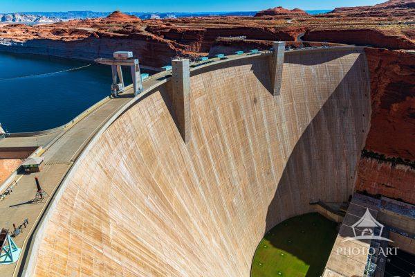 The Glen Canyon dam structure curving across a deep canyon creating Lake Powell behind it The river