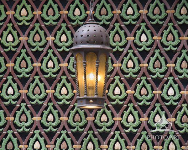 An ornate hanging lantern glows against the distinctive, intricate Moorish revival tilework on the