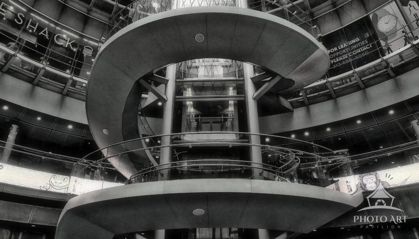 This dramatic vertical photograph showcases the striking, sculptural spiral staircase located within